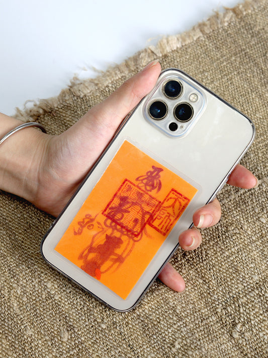 a mobile phone charm or sticker featuring a traditional Chinese Taoist talisman, hand-drawn by a Zhengyi lineage master from Longhu Mountain.