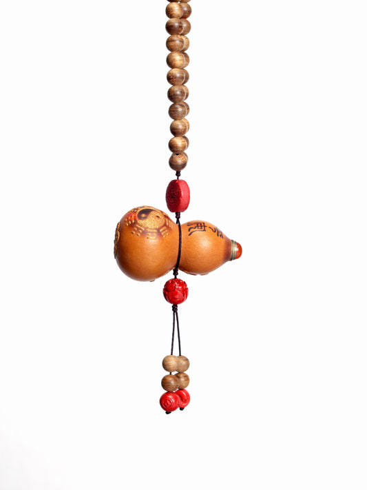 This item is crafted with a base of natural Agarwood, known for its elegant and spirit-nourishing properties. It is accented with beads of pure yang Cinnabar and a small, natural gourd, creating a personal ritual object that combines aromatic healing with spiritual protection.